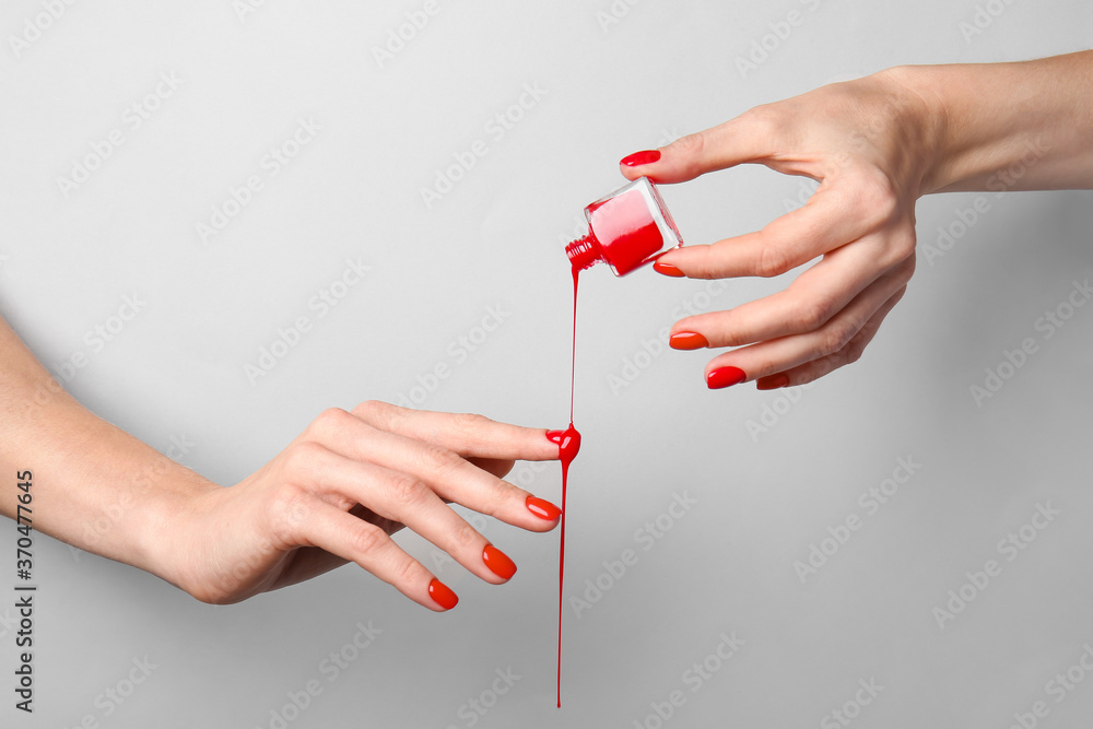 Hands with nail polish on grey background