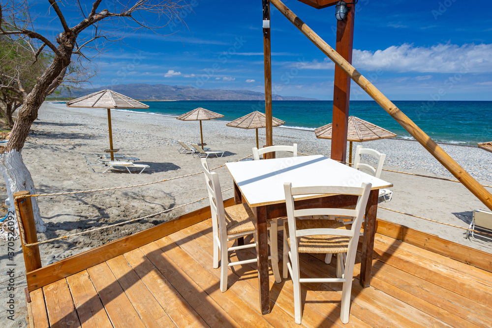 Empty restaurant tables at the Maleme beach on Crete, Greece