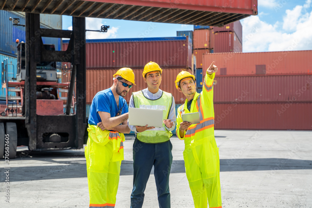 Workers inspecting cargo containers at cargo logistic warehouse,Import and export concept.