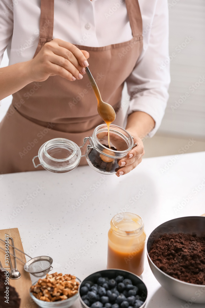 女人在罐子里准备美味的纸杯蛋糕