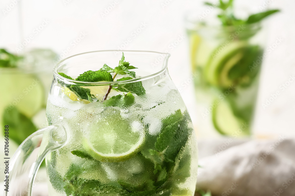 Jug of fresh mojito on table