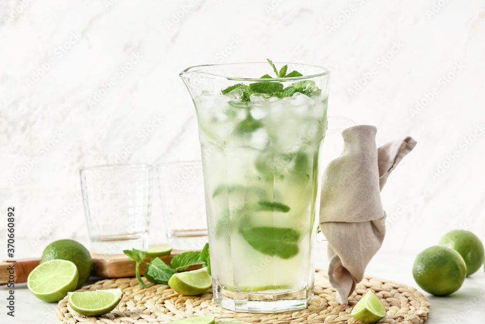 Jug of fresh mojito on table