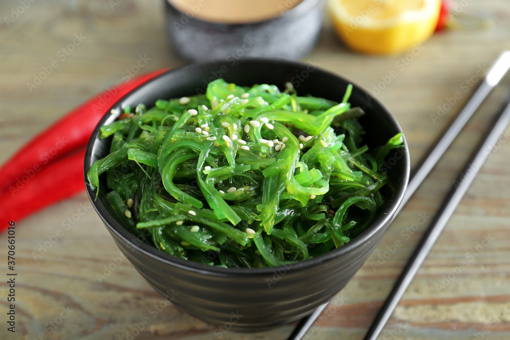 Bowl with tasty seaweed salad on table, closeup