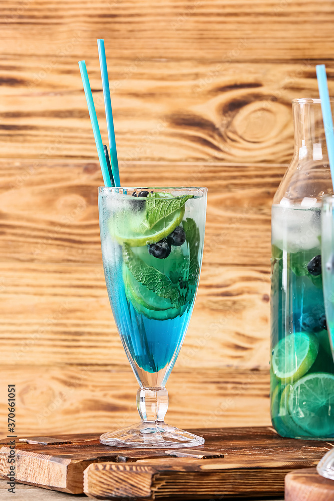 Glass of tasty blue mojito cocktail on table