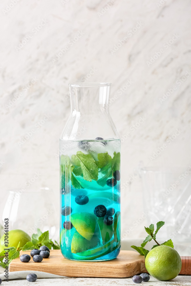 Bottle of tasty blue mojito cocktail on white background