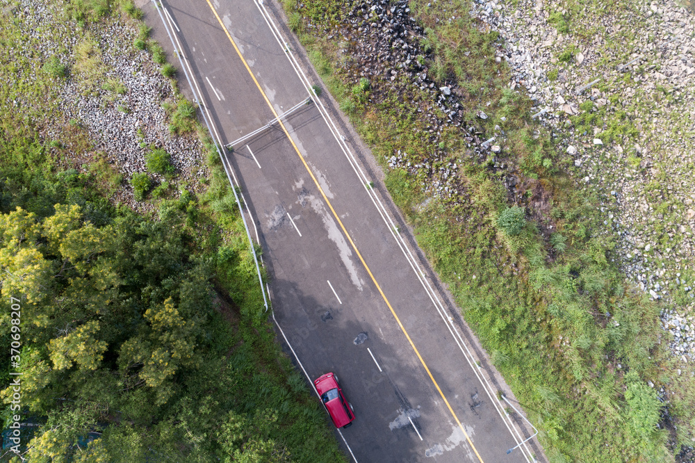 飞行无人机拍摄的沥青路面、红色suv汽车和da周围道路的俯视图