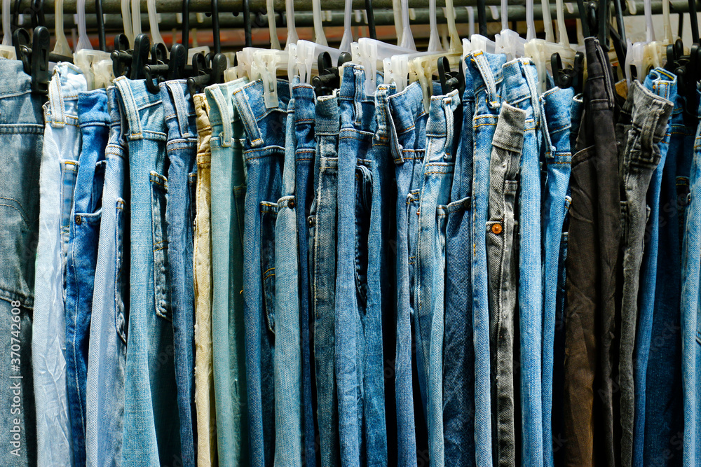 assortment of blue jeans hanged in a shop 