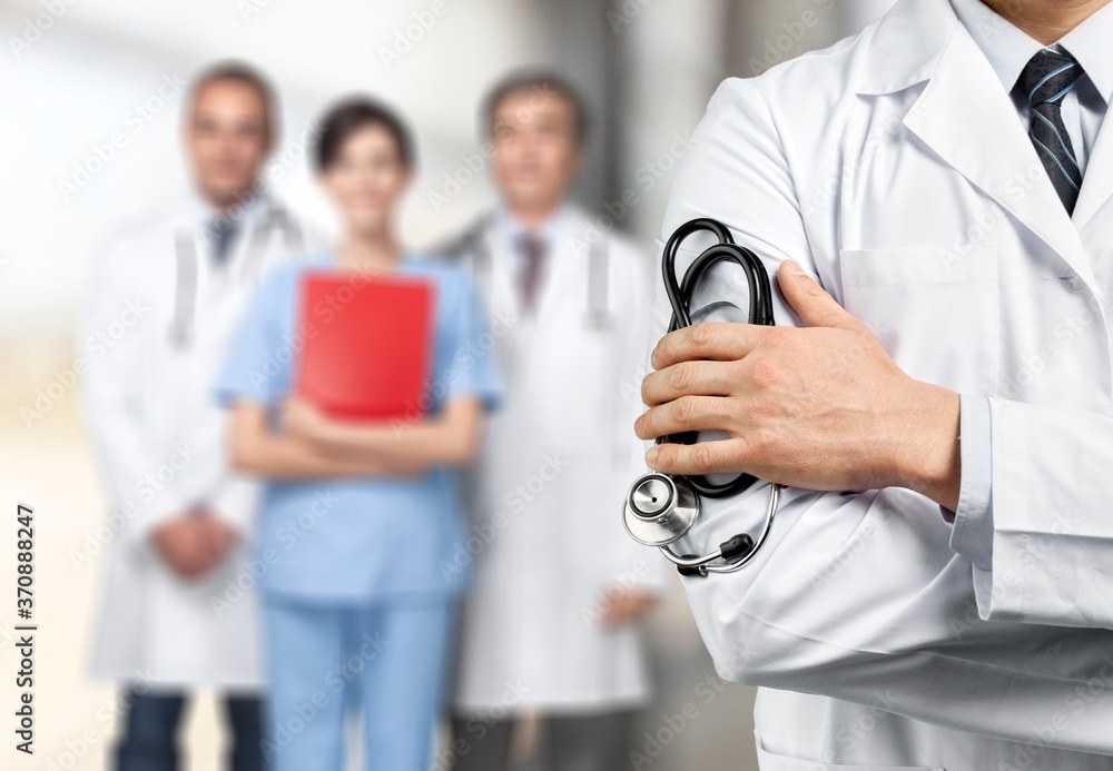 Young man doctor holding stethoscope on medical team background