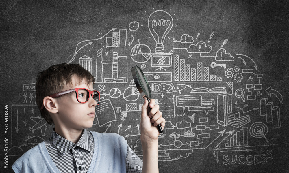 Curious school boy with magnifier