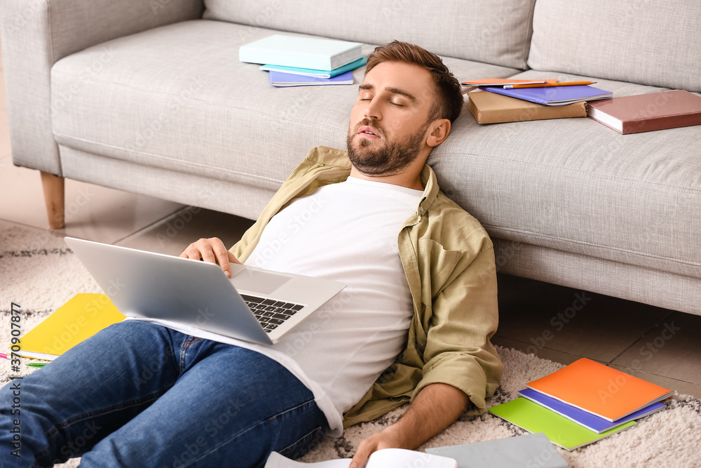 Tired male student sleeping at home