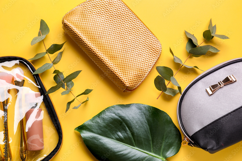 Composition with cosmetic bags on color background