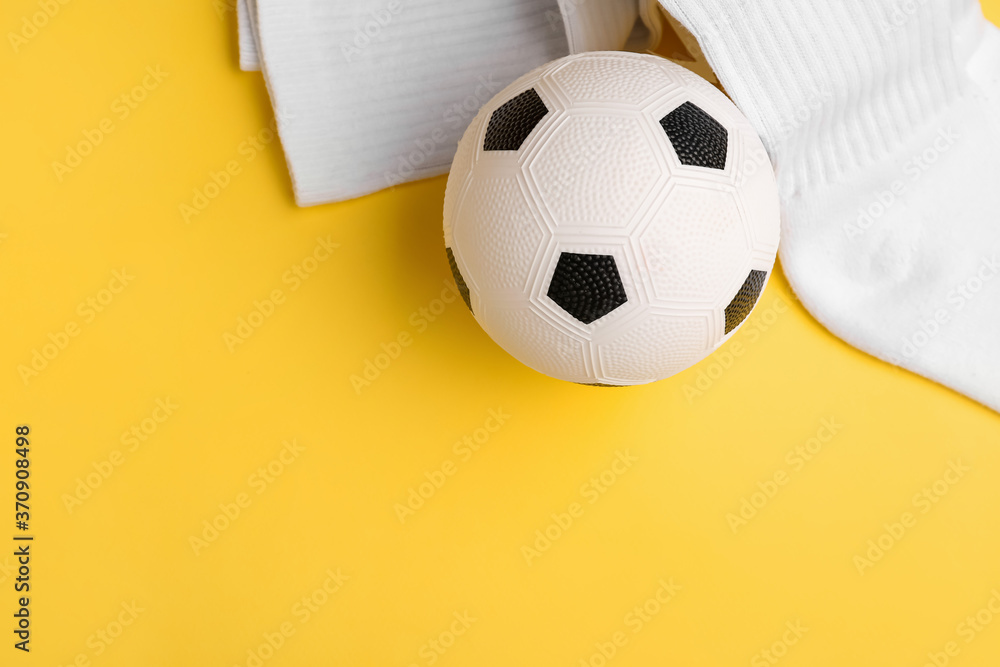 Soccer ball and socks on color background