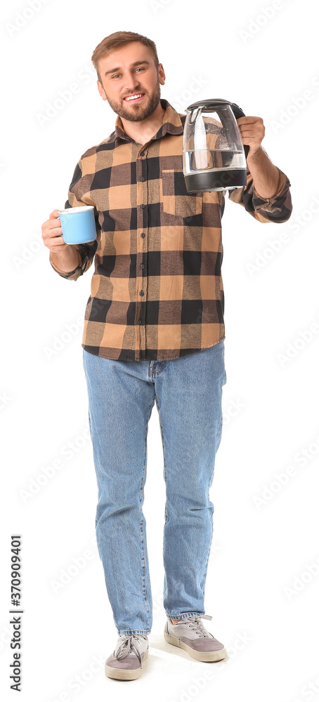 Young man with electric kettle and cup on white background