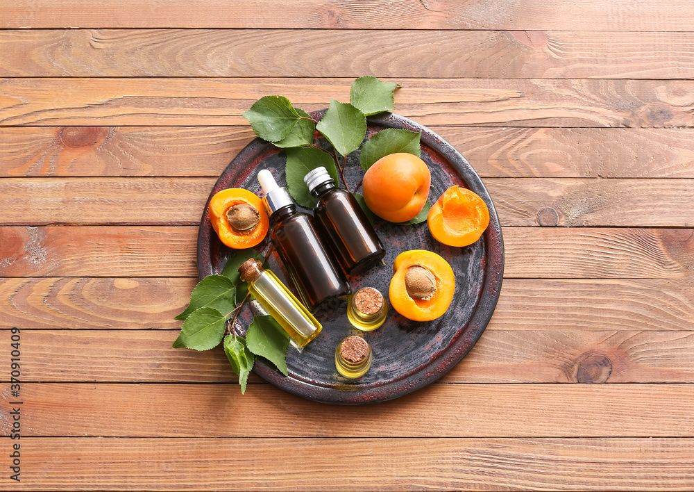 Bottles of apricot essential oil on table