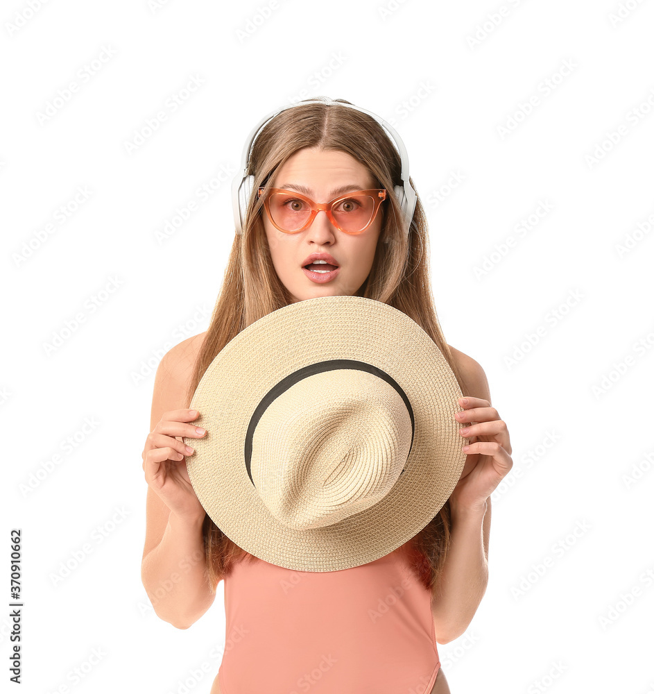 Surprised woman with headphones and hat on white background