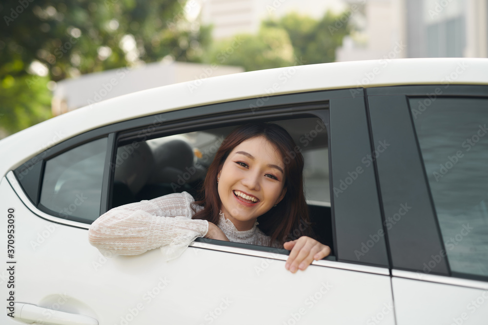 Young asian woman looks out of the car window