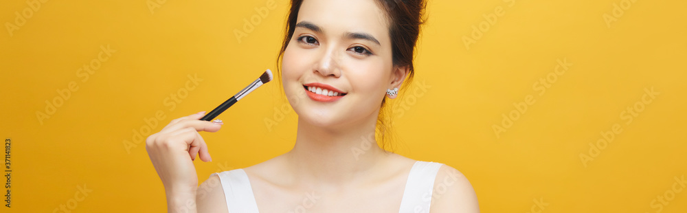 Woman applying make up with brush, isolated. Beauty procedures