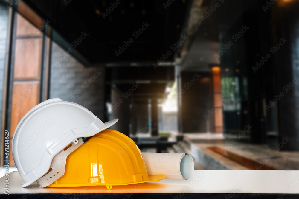 Construction house and building. Repair work. Drawings for building and helmet on white table.