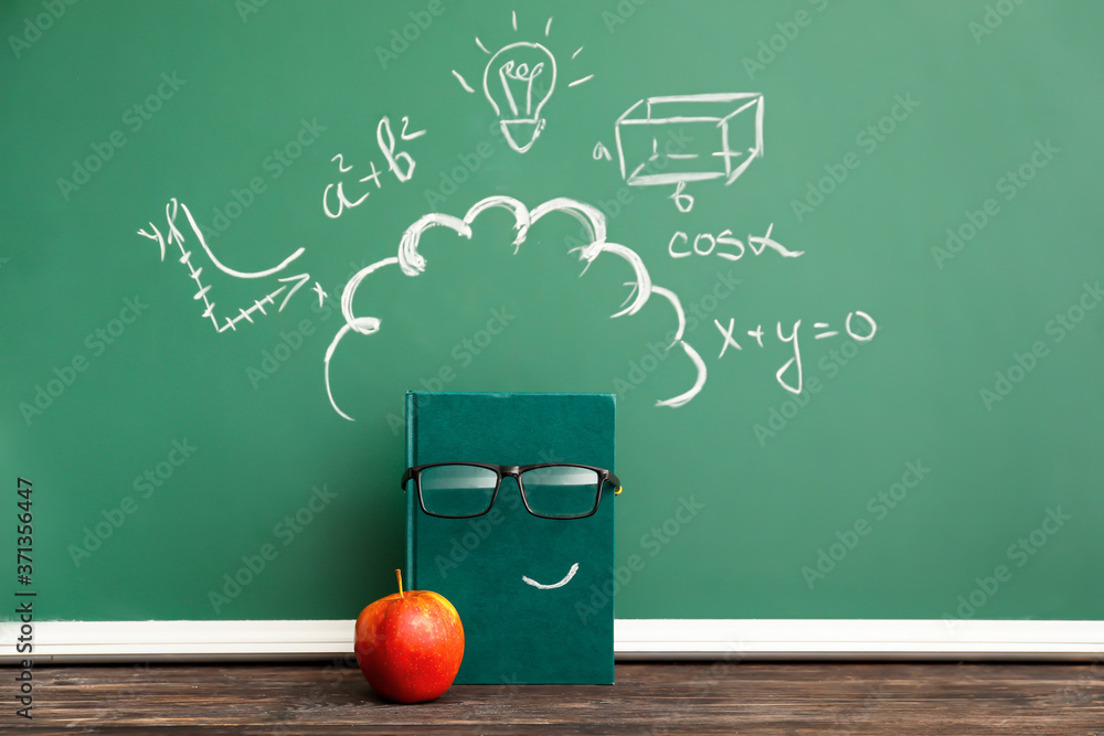 Creative composition with notebook, apple and school blackboard