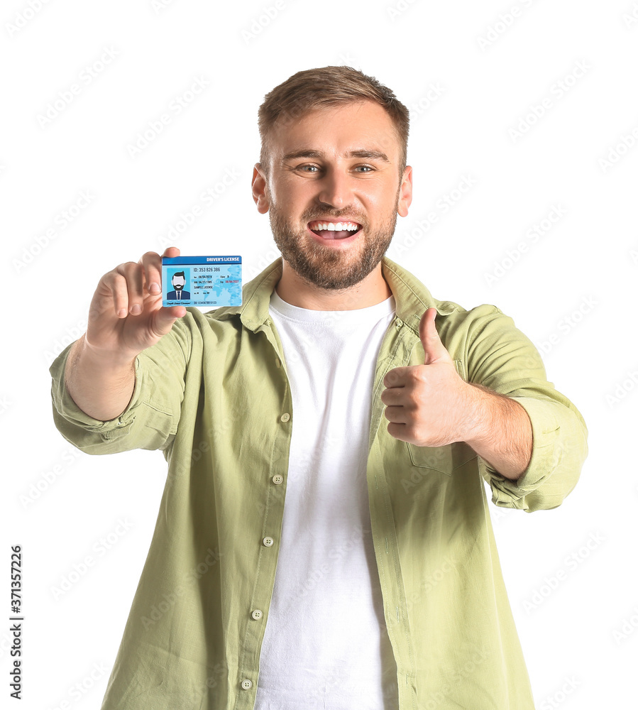 Happy young man with driving license on white background