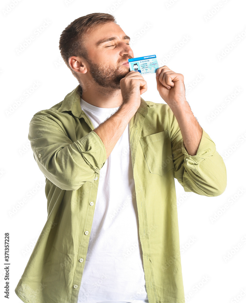 Happy young man with driving license on white background