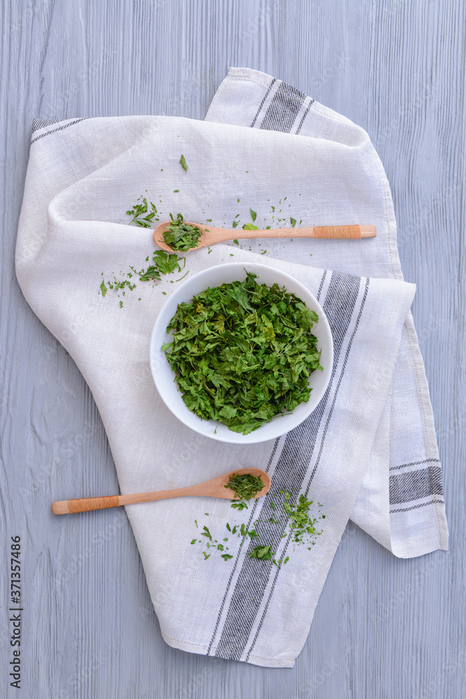 Bowl with dry parsley on table