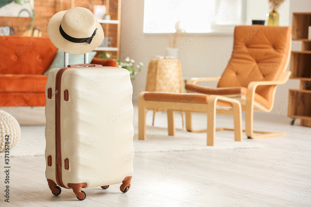 Packed suitcase with hat at home. Travel concept