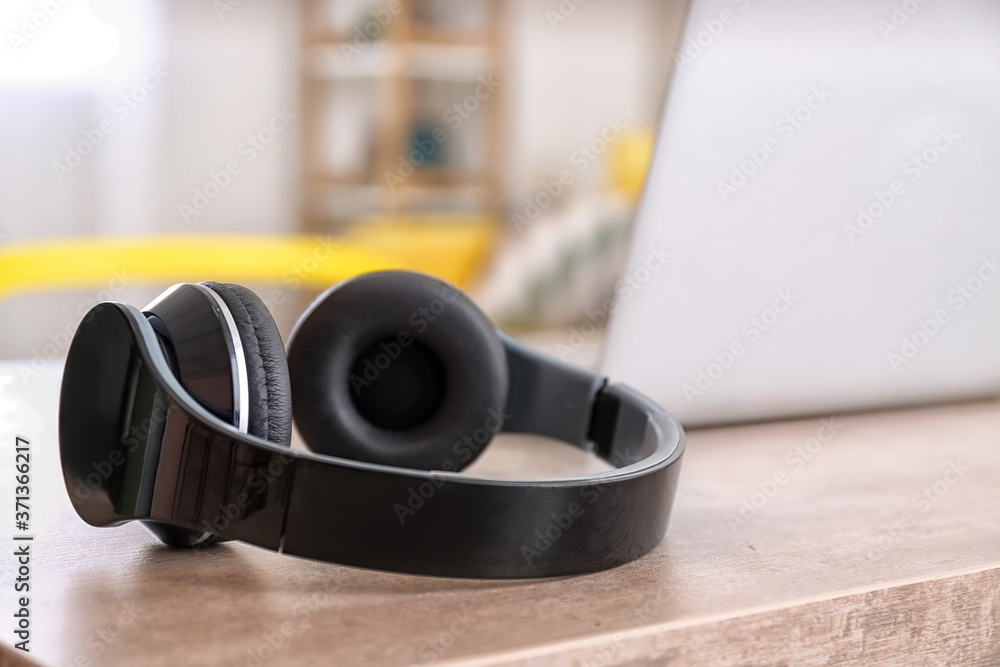 Modern headphones on table in room