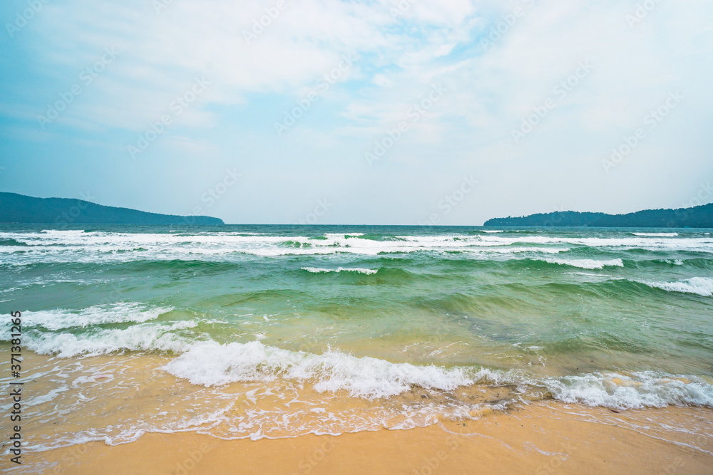 海滩，白色的沙滩，蓝色的海水和郁郁葱葱的绿色热带丛林，地平线上的绿色小岛。