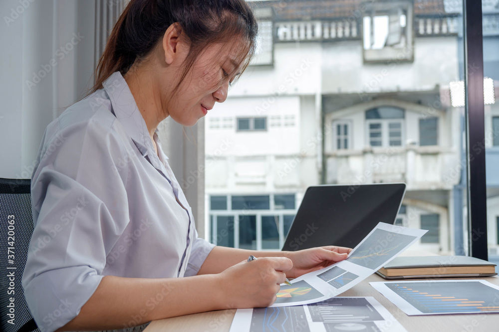 Portrait beautiful asian businesswoman working in her home, office, looking at graphs, financial mar