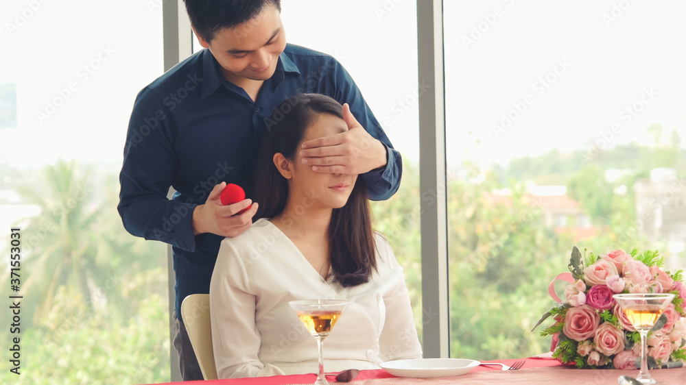 Romantic couple giving gift to lover at restaurant . Happy couple lifestyle .