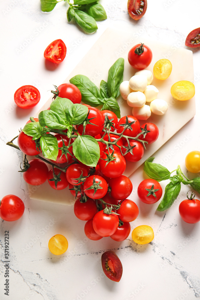 Composition with fresh cherry tomatoes, mozzarella cheese and spices on table