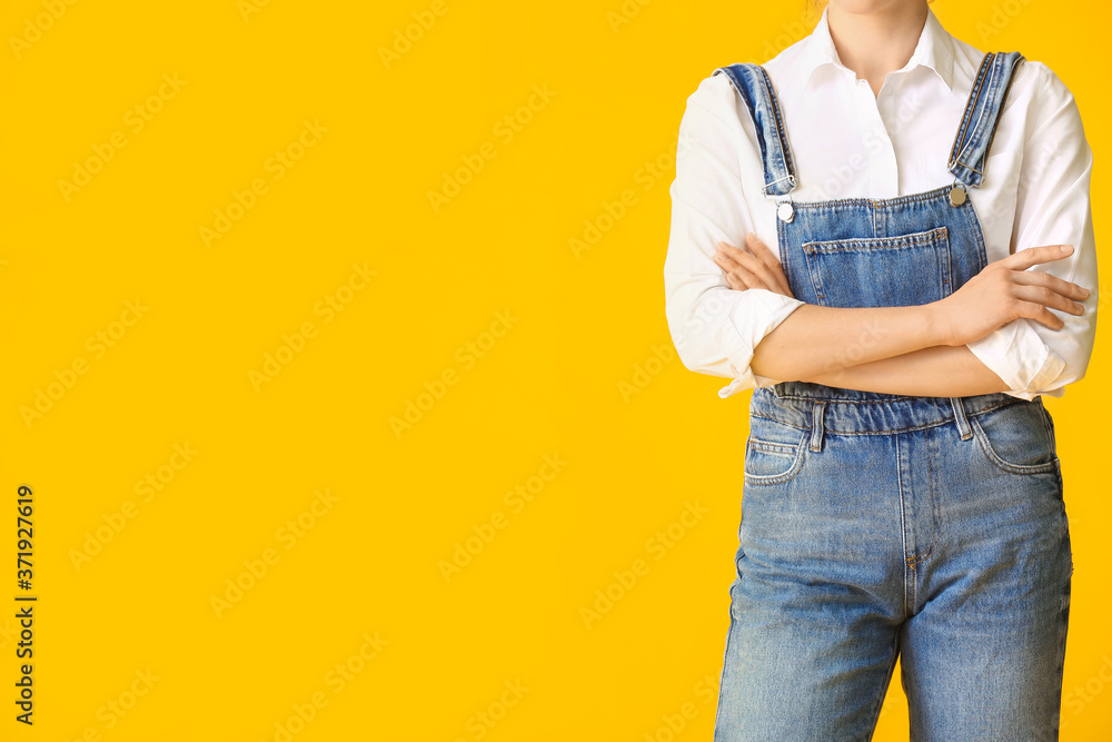 Beautiful young woman in jeans clothes on color background