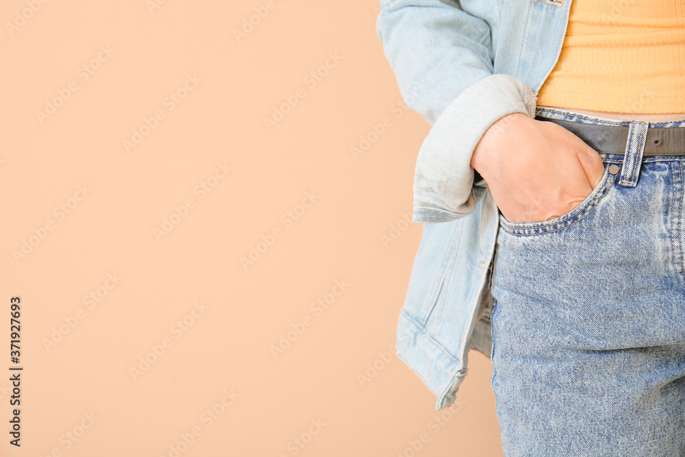 Beautiful young woman in jeans clothes on color background, closeup