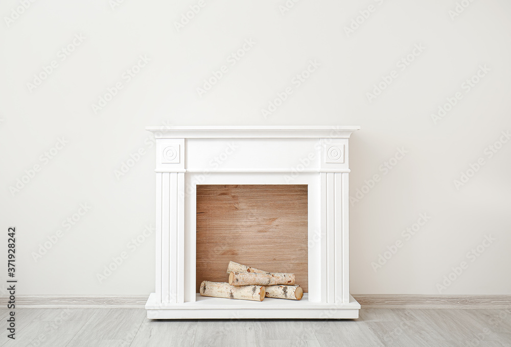 Modern fireplace near wall in room