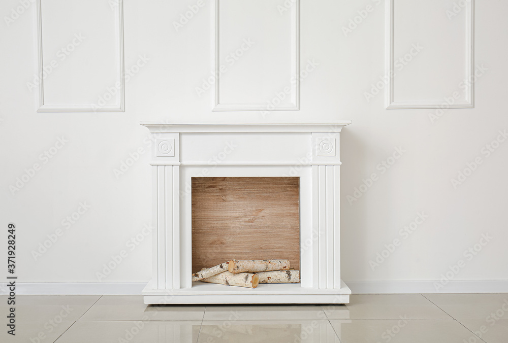 Modern fireplace near wall in room