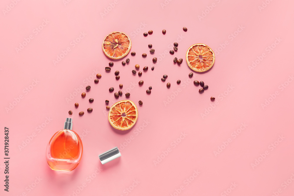 Bottle of perfume, orange and coffee beans on color background