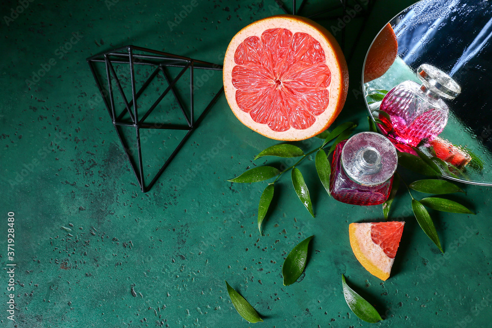 Bottle of citrus perfume and grapefruit on table