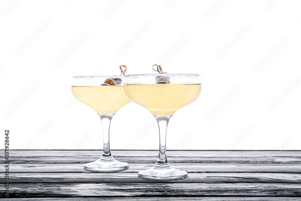 Glasses of fresh martini on table against white background