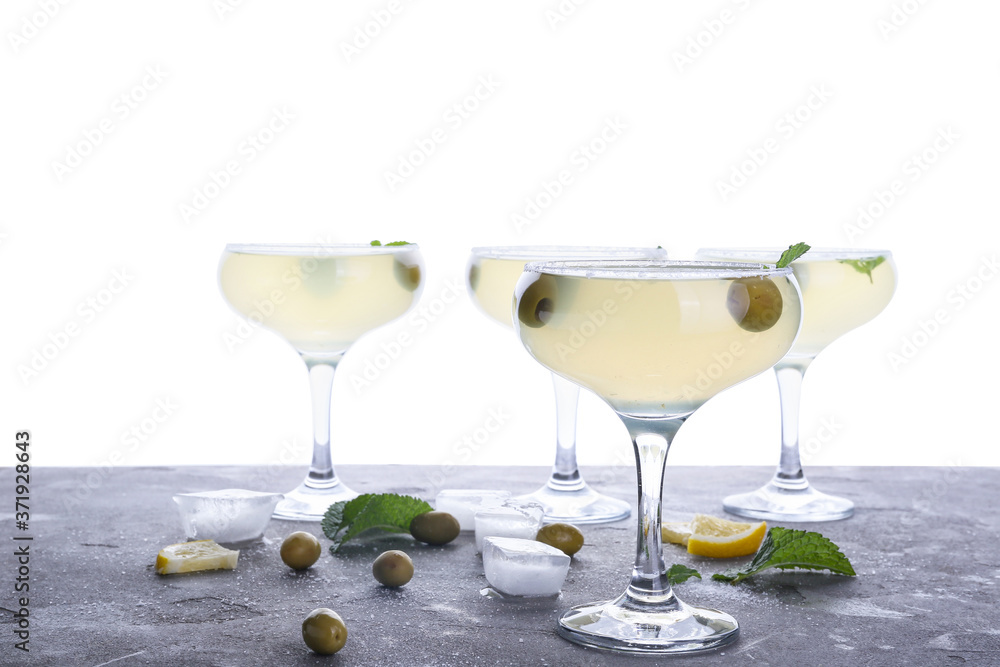 Glasses of fresh martini on table against white background