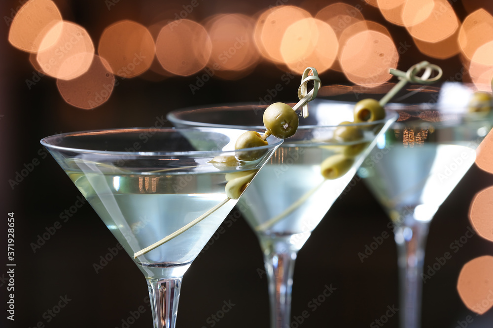 Glasses of fresh martini on dark background, closeup