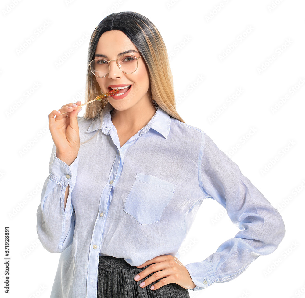 Beautiful young woman in wig and with lollipop on white background