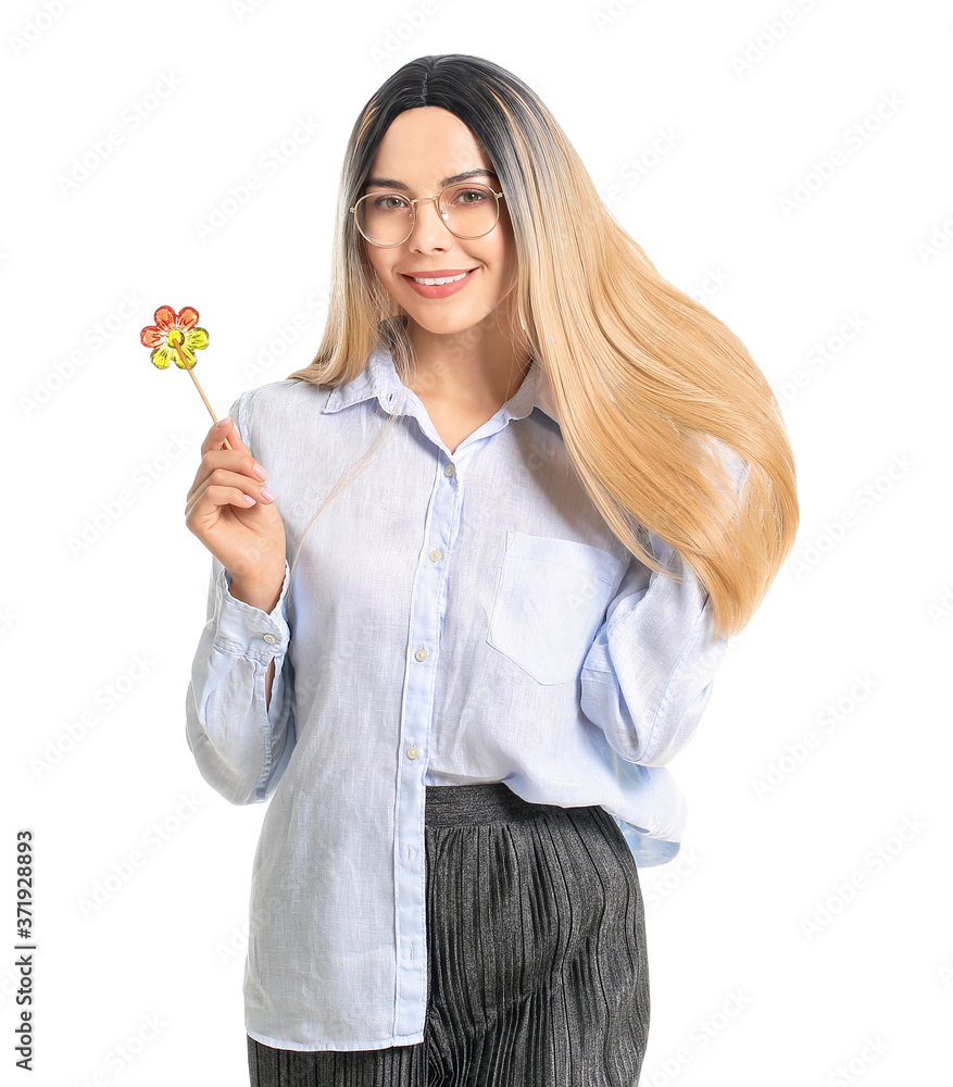 Beautiful young woman in wig and with lollipop on white background