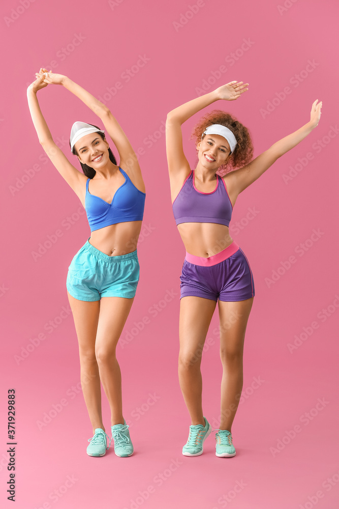 Young women doing aerobics on color background