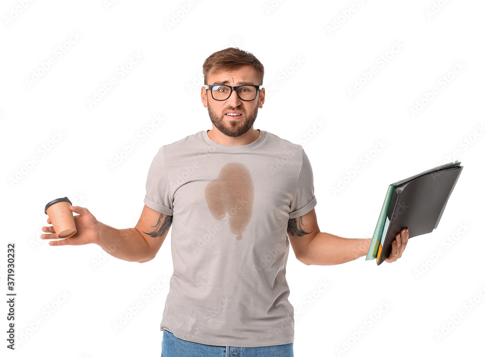 Stressed young businessman with coffee stains on his t-shirt on white background