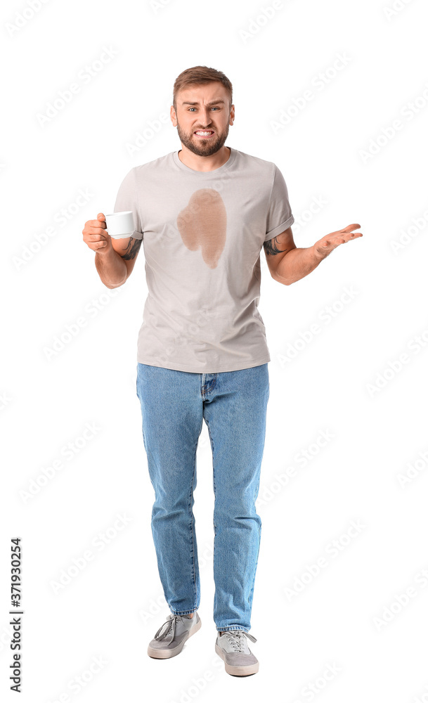 Stressed young man with coffee stains on his t-shirt on white background