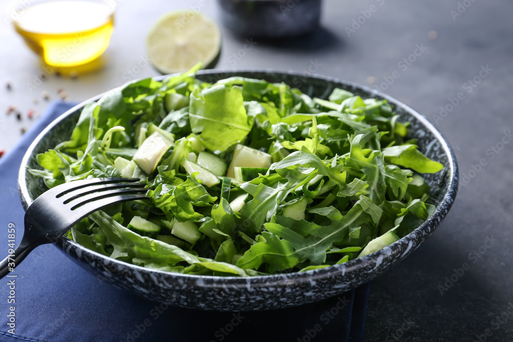 Plate with tasty cucumber salad on dark background