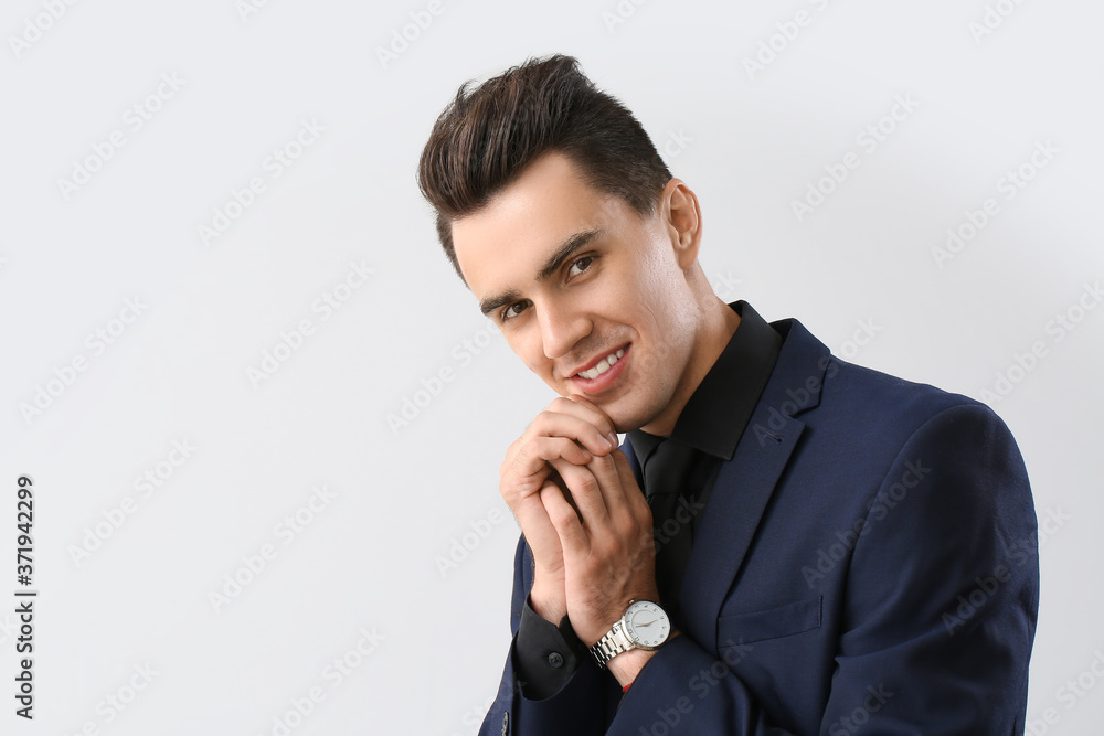 Handsome man with stylish hairdo on light background