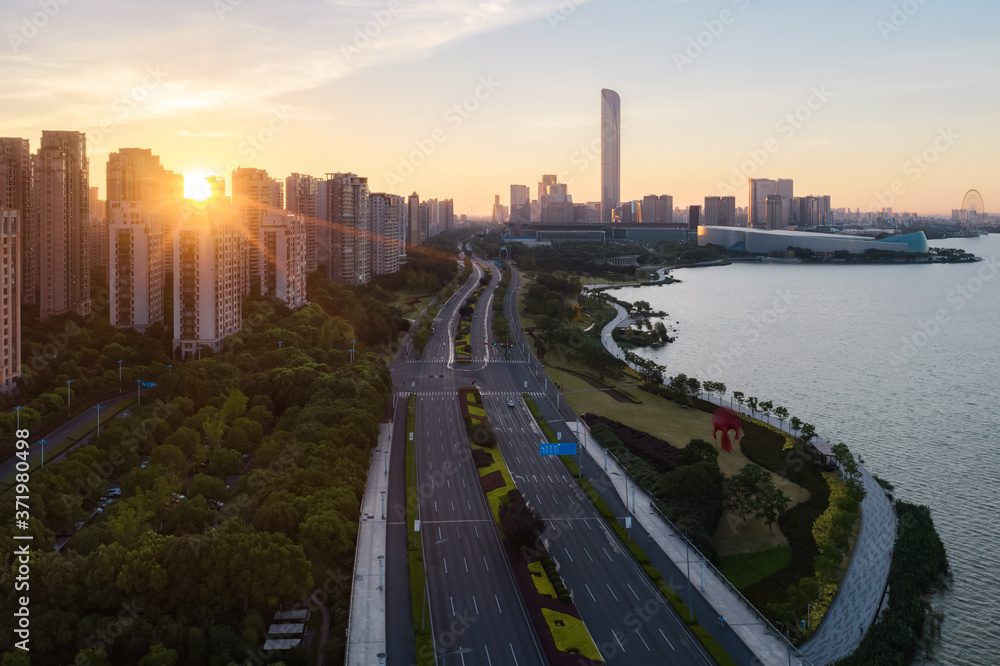 与中国苏州金鸡湖畔的CBD建筑一起日出。