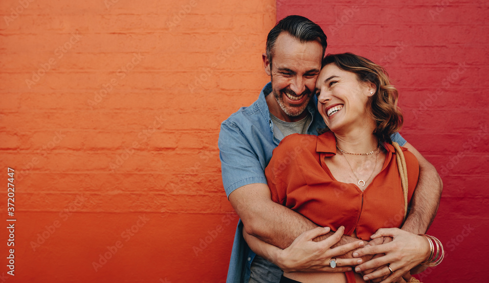 Romantic couple together on multicolored wall